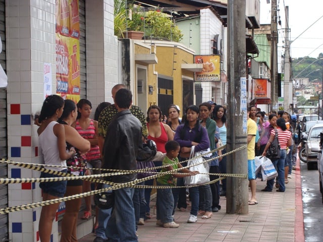 Pessoas dormem na fila para aproveitar os produtos de liquidação em Itabira
