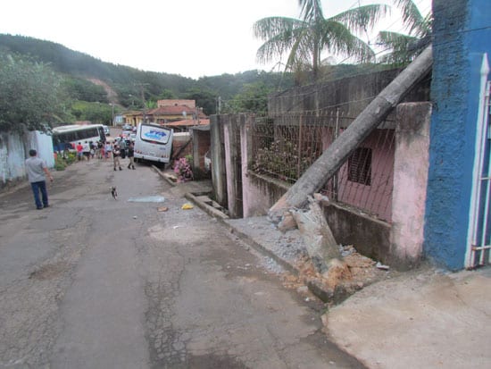 Ônibus desce rua desgovernado, derruba dois postes sobre casas e fere uma pessoa