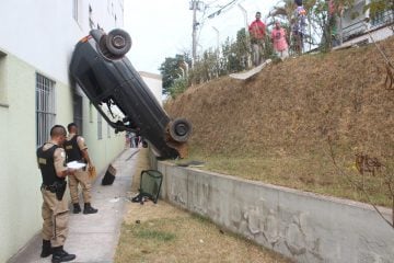Carro cai com casal dentro e fica “escorado” em paredes de um prédio em Itabira