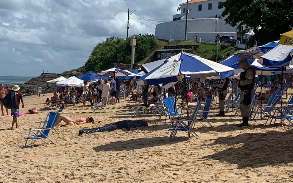 Mulher toma sol ao lado de cadáver em praia baiana