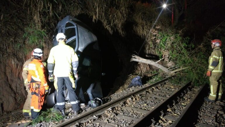 Carro cai em barranco próxima a linha férrea e quase é atingido por trem