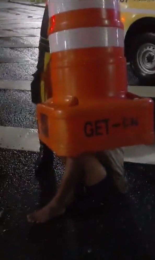 Homem se esconde dentro de cone, entala e precisa da ajuda de agentes para sair; veja o vídeo