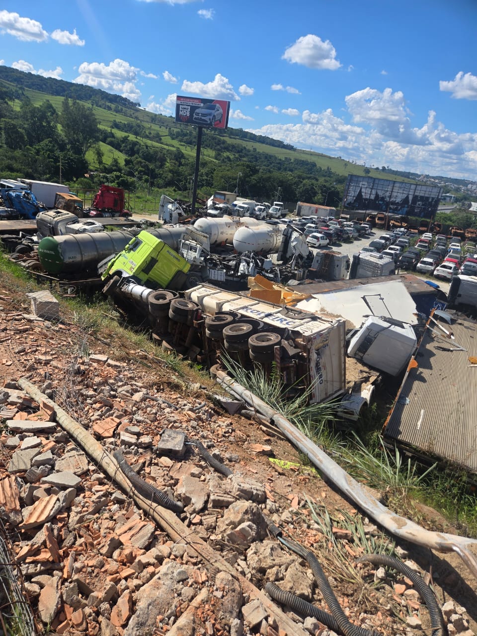 Caminhão capota e cai em barranco em Vespasiano; equipes atuam no resgate