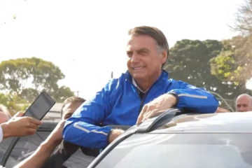 De tornozeleira, Bolsonaro acena para apoiadores em motociata em Brasília