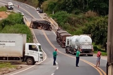 Carreta com carga de milho tomba sobre ponte e interdita BR-262 na Serra do Macuco