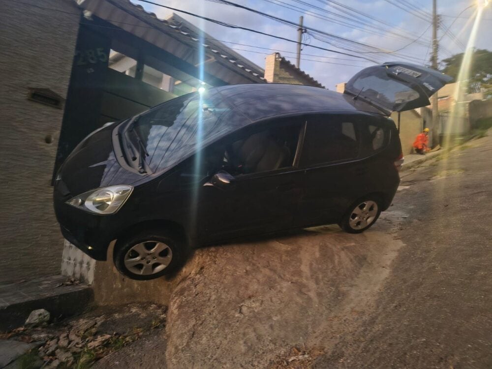 Motorista perde controle em rua íngreme de Belo Horizonte e fica com carro pendurado sobre pedra