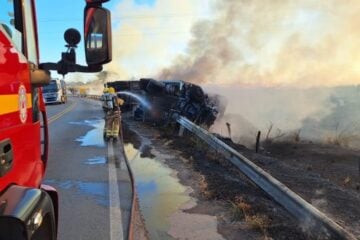 Carreta carregada de minério tomba e pega fogo na BR-354