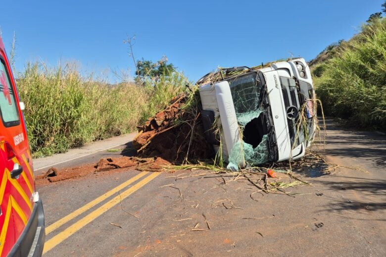 Carreta carregada com grama tomba na BR-262, em São Domingos do Prata; trânsito funciona em “pare e siga”